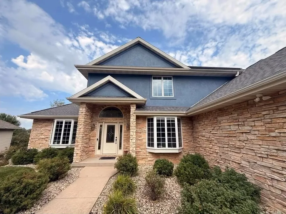 Two-story stucco and stone home after exterior painting
